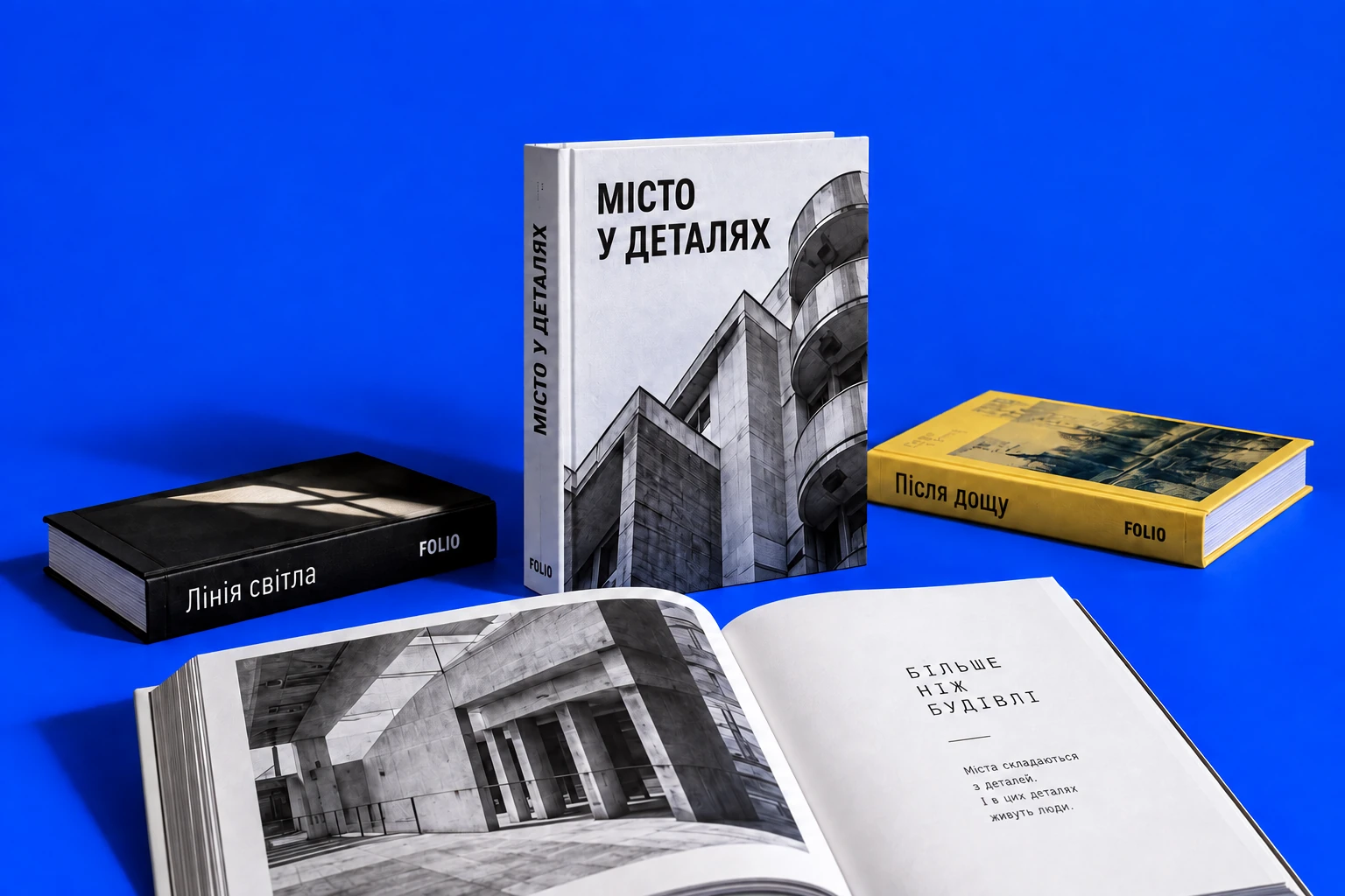 Фізичні книги FOLIO та відкритий альбом на синьому тлі
